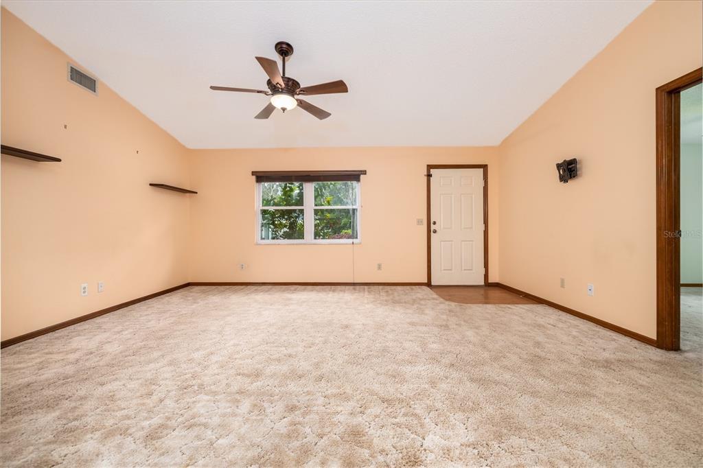 3221 Lime Tree Drive Edgewater, FL 32141 - Photo 13 of 28 an empty room with a ceiling fan and windows