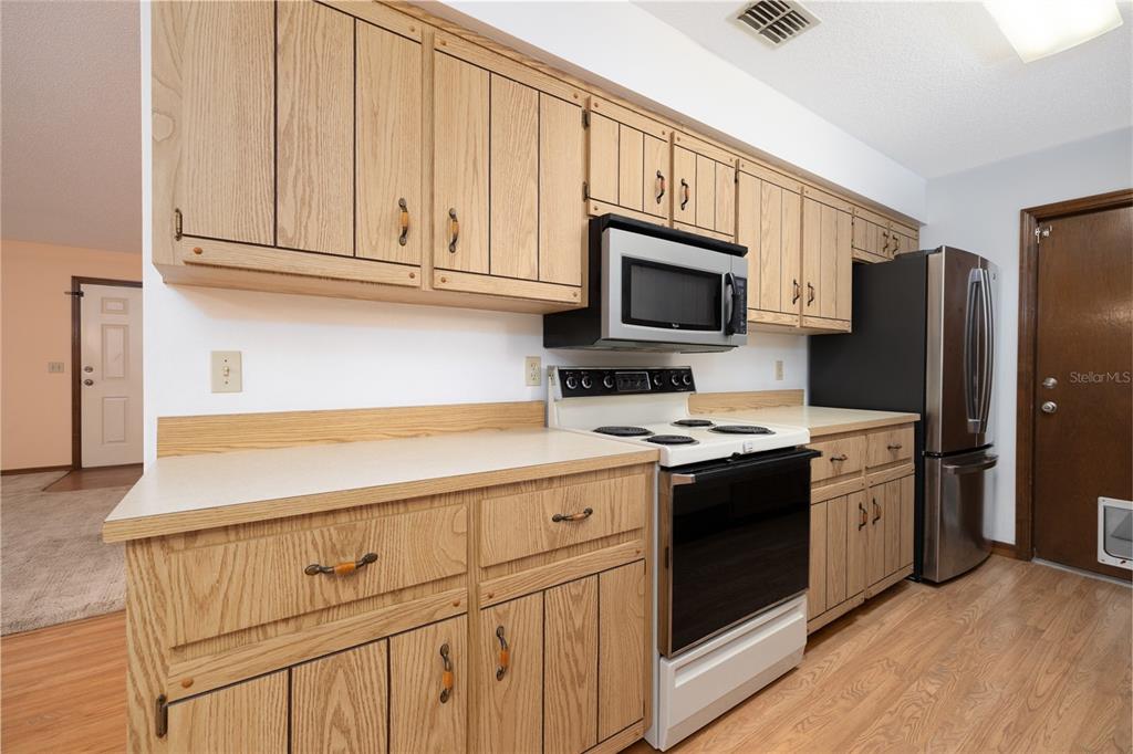 3221 Lime Tree Drive Edgewater, FL 32141 - Photo 14 of 29 a kitchen with cabinets stainless steel appliances and wooden floor