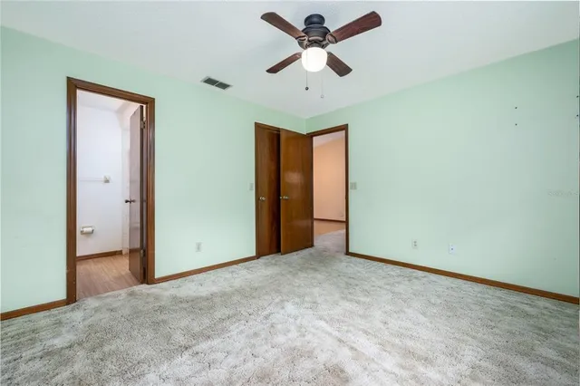an empty room with closet and fan