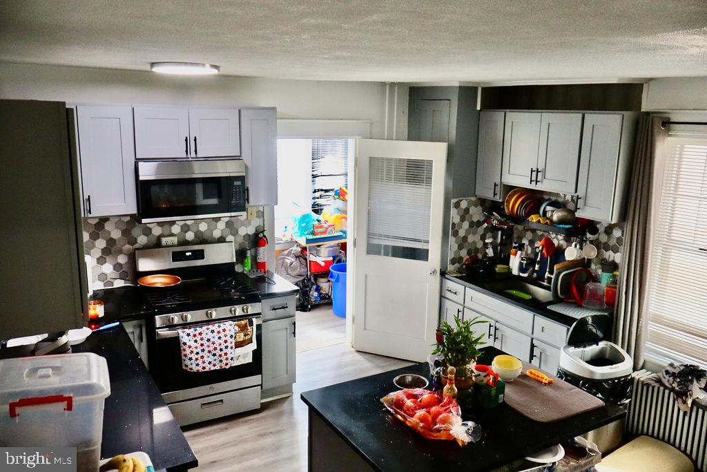 3420 Penn Avenue Sinking Spring, PA 19608 - Photo 11 of 34 a living room with furniture a flat screen tv and a refrigerator