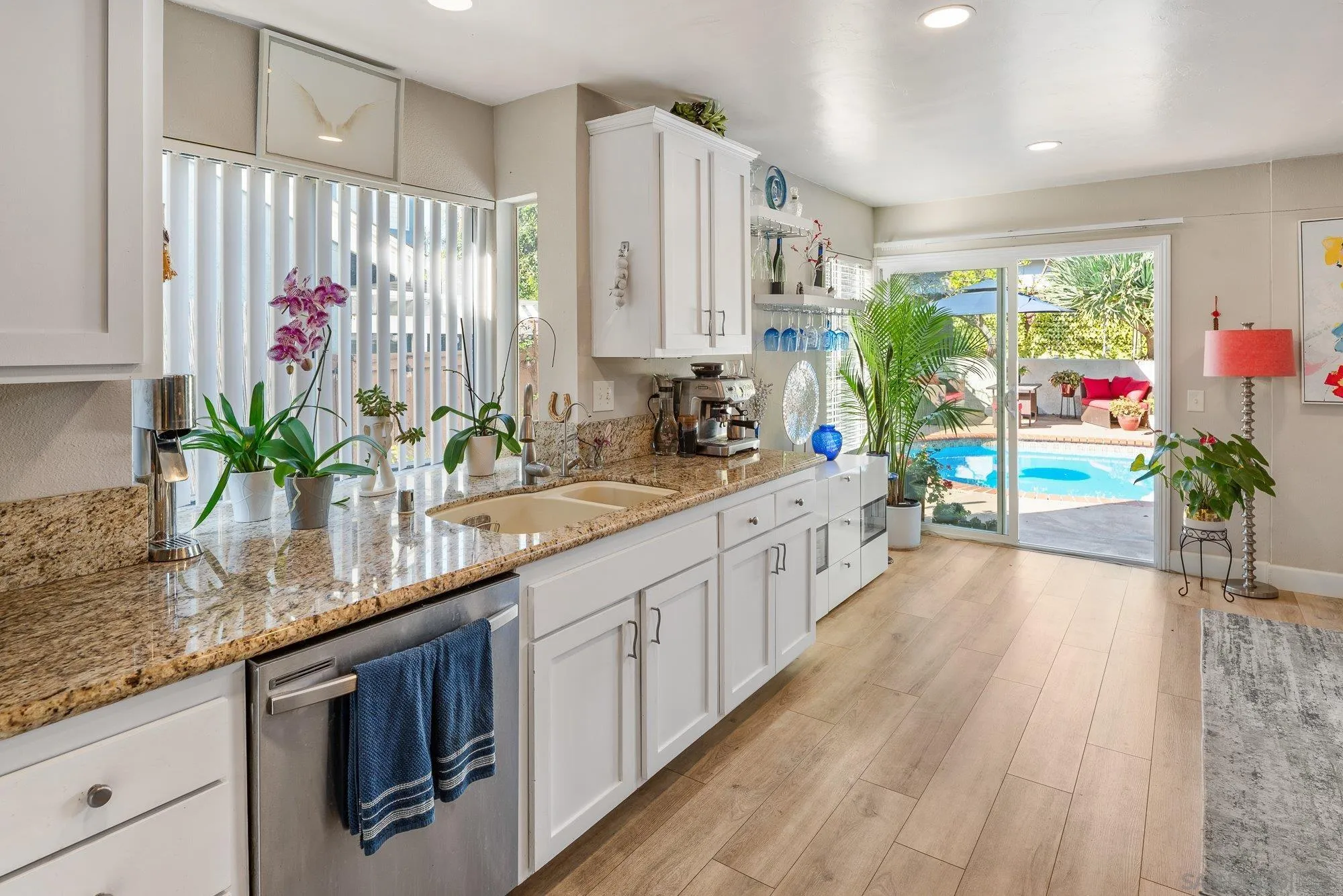 3598 Old Cobble Road San Diego, CA 92111 - Photo 18 of 42 a kitchen with stainless steel appliances kitchen island granite countertop lots of counter top space and wooden floor