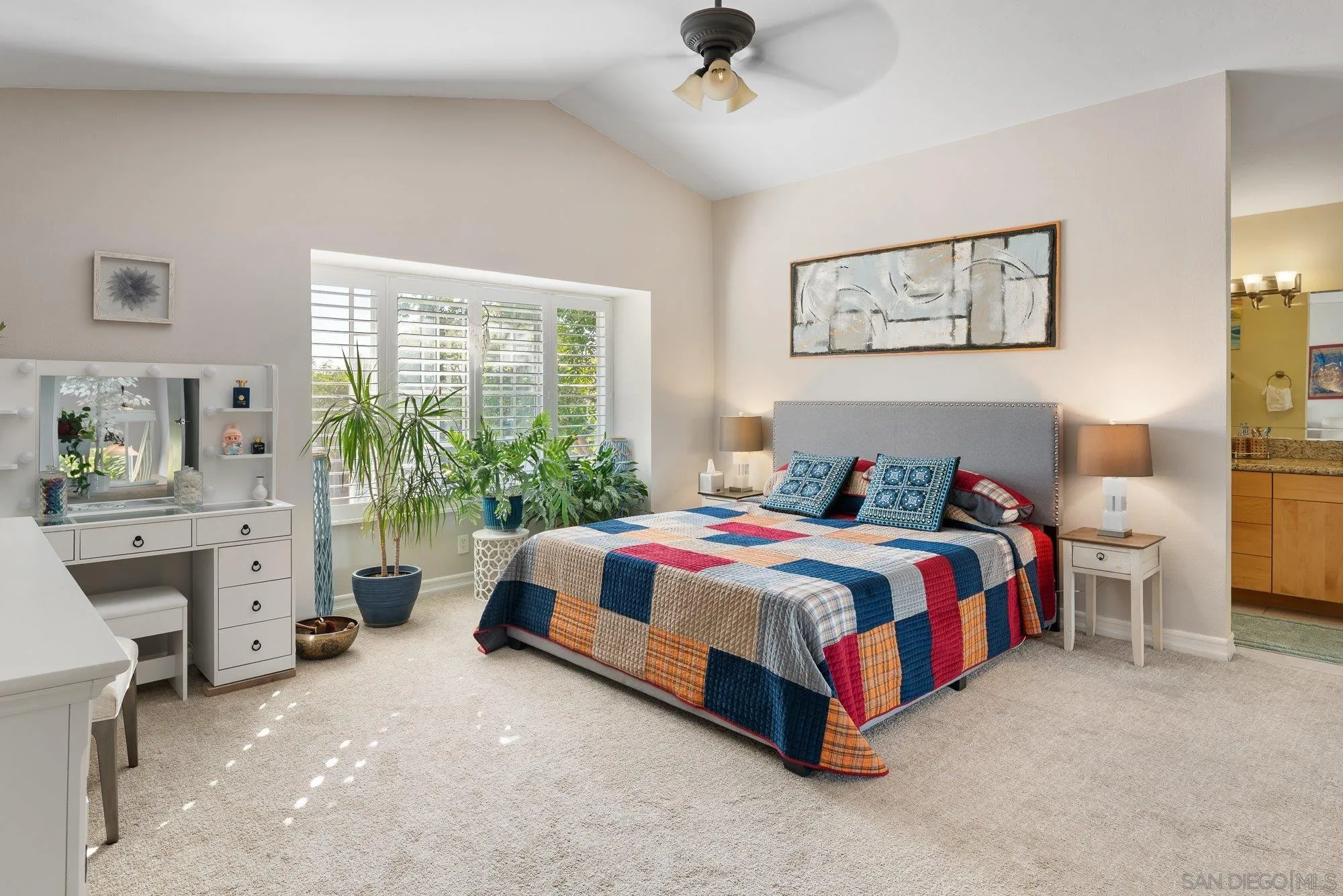 3598 Old Cobble Road San Diego, CA 92111 - Photo 25 of 42 a spacious bedroom with a bed and a chandelier
