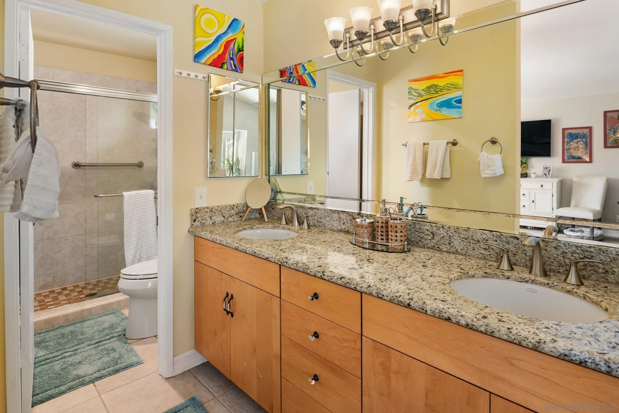 3598 Old Cobble Road San Diego, CA 92111 - Photo 28 of 42 a bathroom with a granite countertop sink mirror and a shower