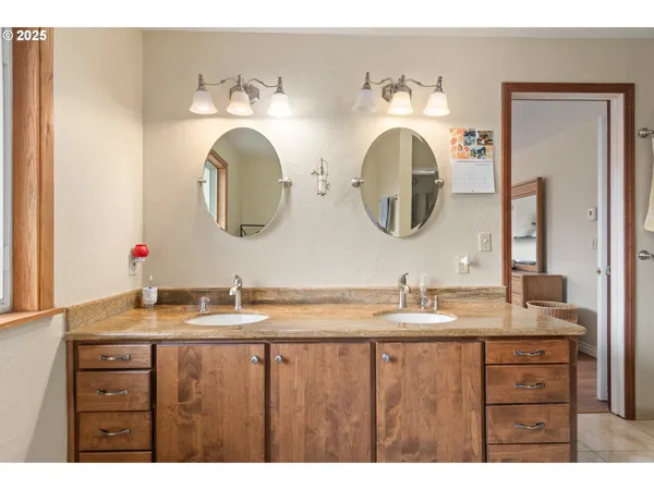 a bathroom with a double vanity sink and a mirror