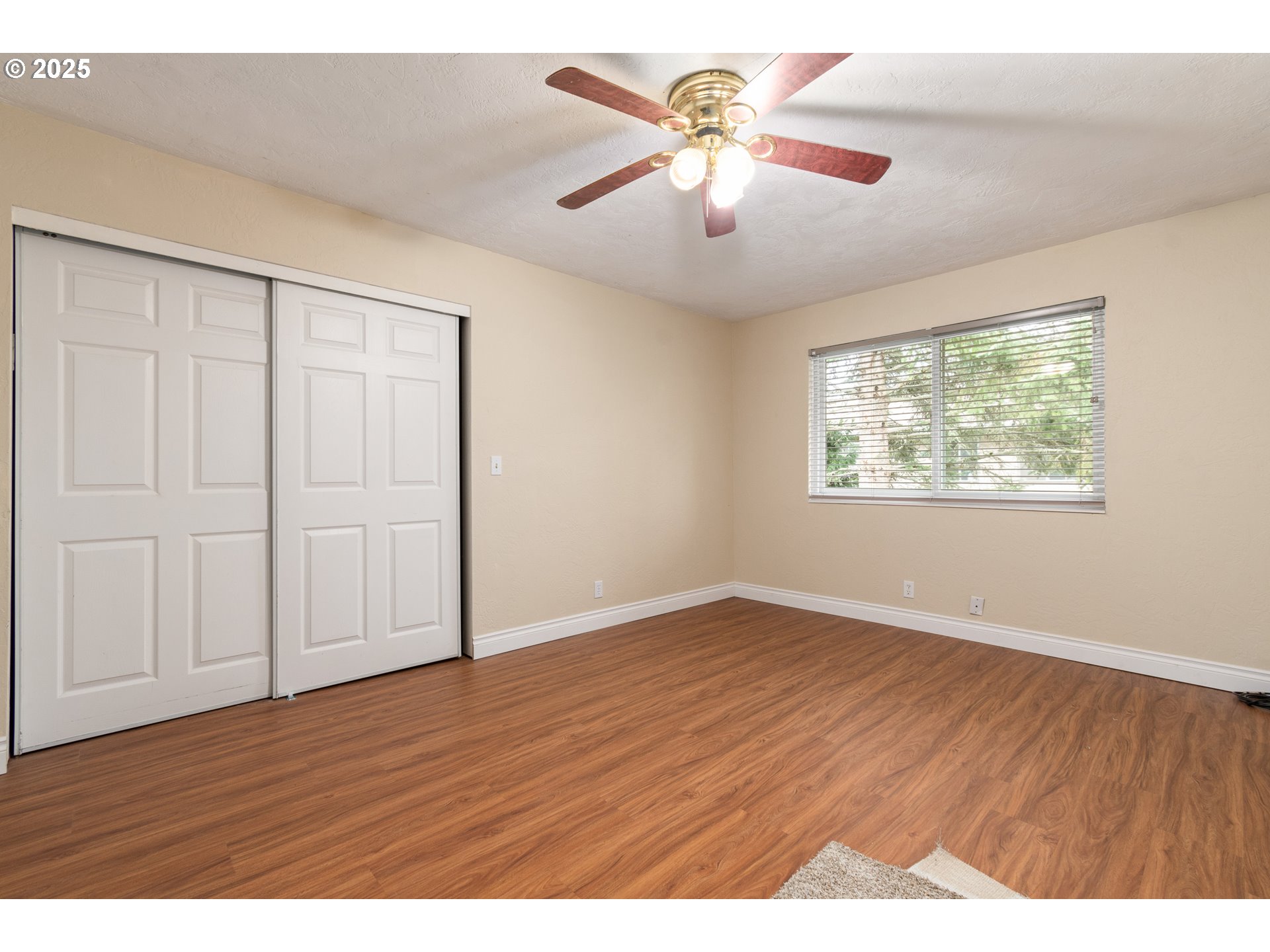 2746 Harlow Road Eugene, OR 97401 - Photo 19 of 22 an empty room with wooden floor chandelier fan and windows