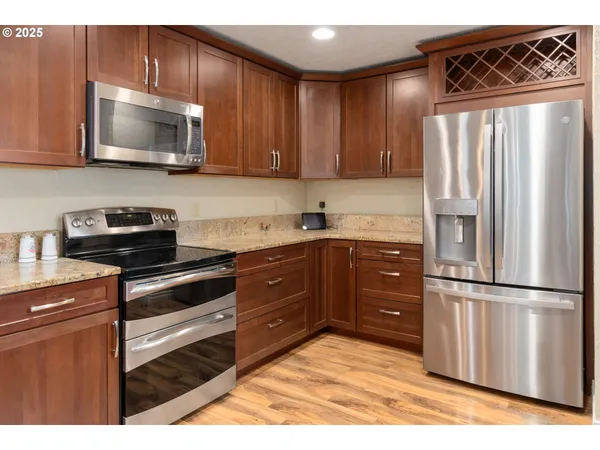 a kitchen with stainless steel appliances granite countertop a refrigerator microwave and sink