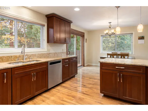a kitchen with granite countertop stainless steel appliances sink and large window