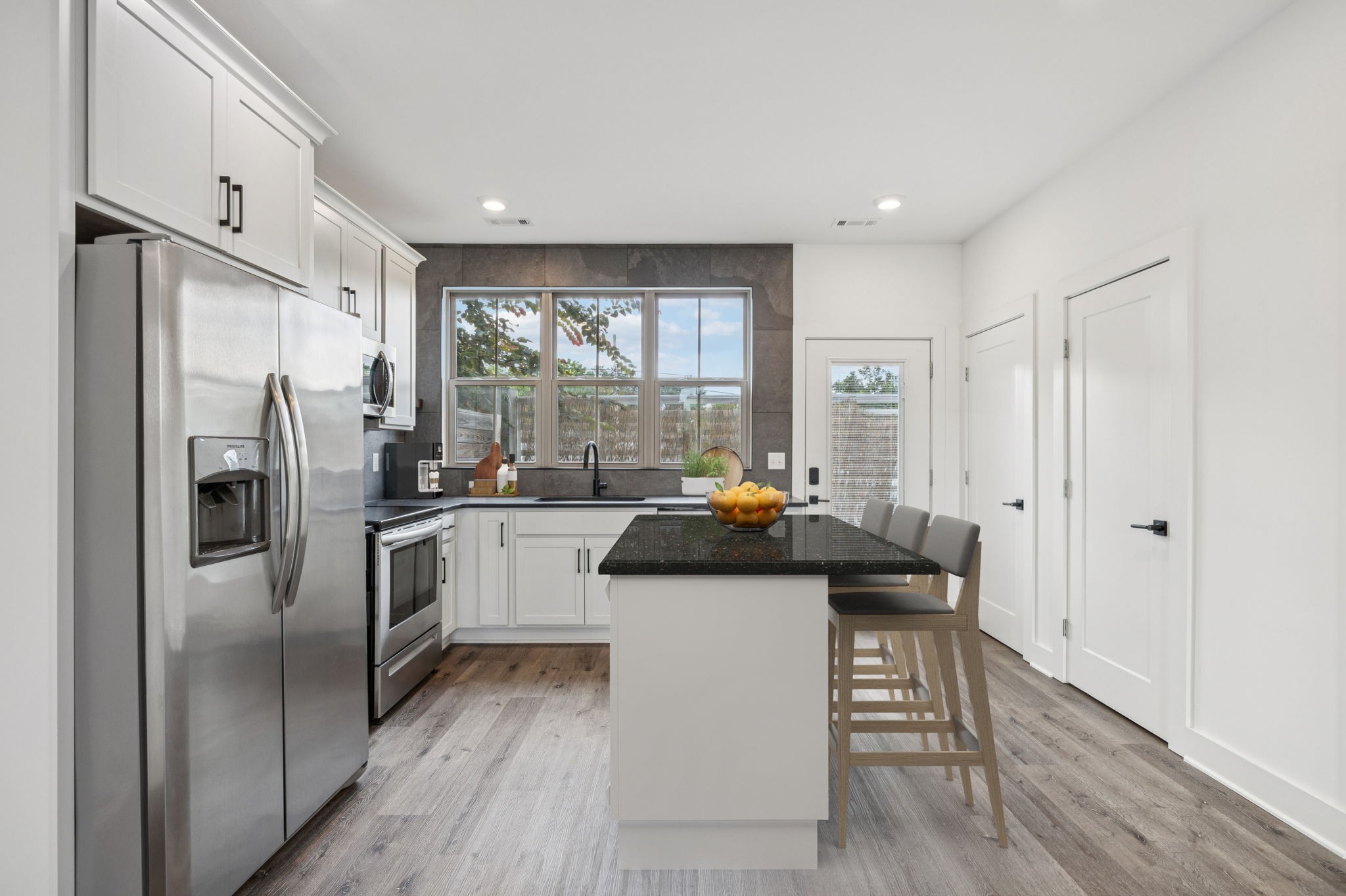 a kitchen with a refrigerator a sink and white cabinets