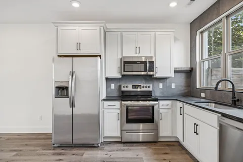 a kitchen with stainless steel appliances granite countertop a refrigerator stove and sink