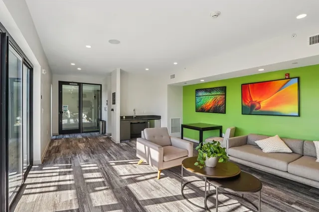 a living room with furniture a rug and a flat screen tv