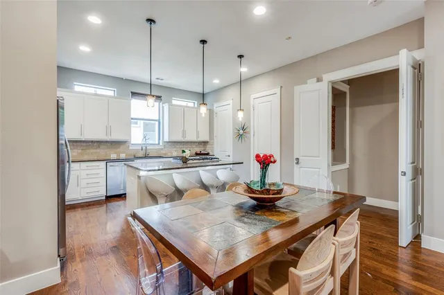 a kitchen with a table chairs refrigerator and microwave
