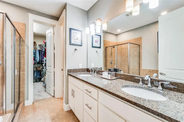 a bathroom with a granite countertop double vanity sink and a mirror