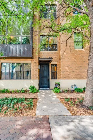 a front view of a house with a yard and potted plants
