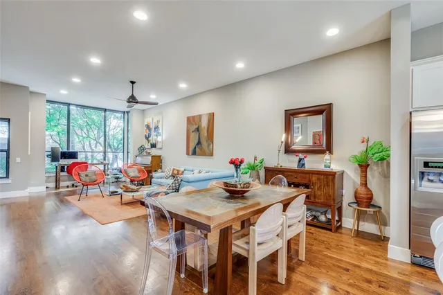 a living room with furniture a dining table and a potted plant
