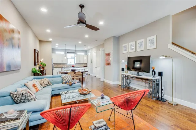 a living room with furniture a flat screen tv and kitchen view