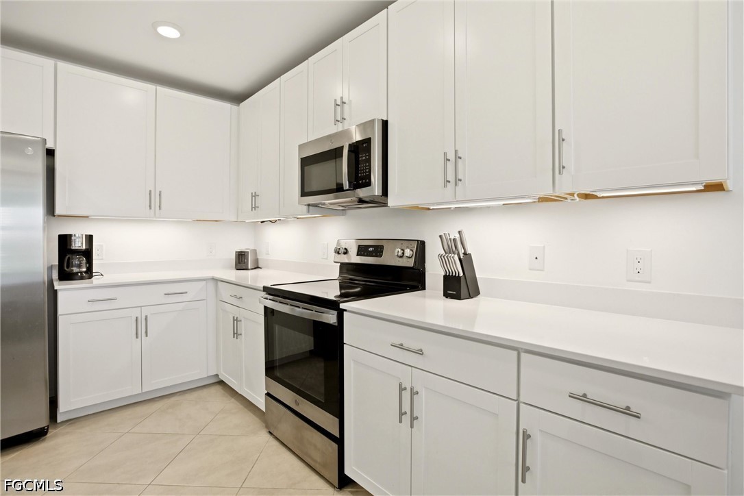 3751 Pebblebrook Ridge Court, Unit 101 Fort Myers, FL 33905 - Photo 7 of 48 a kitchen with white cabinets and white appliances