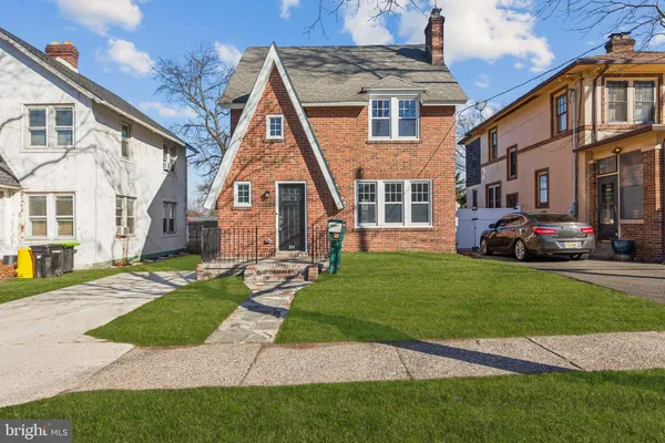 a front view of a house with a garden and plants