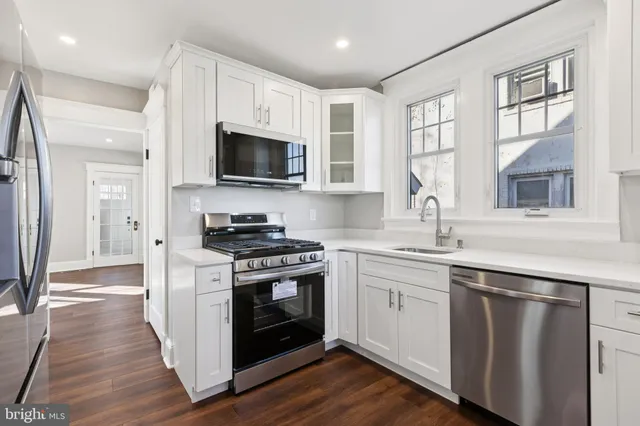 a kitchen with stainless steel appliances granite countertop a stove a sink and a microwave
