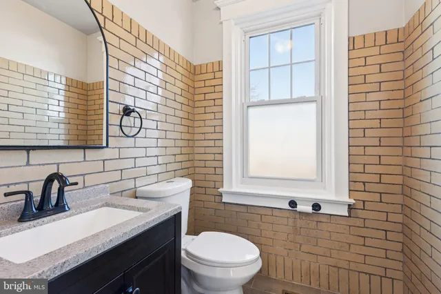 a bathroom with a sink a toilet and mirror
