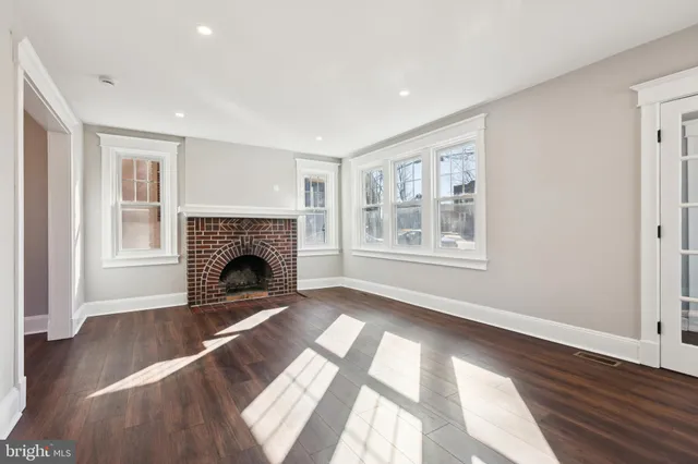 a view of a livingroom with a fireplace wooden floor and window