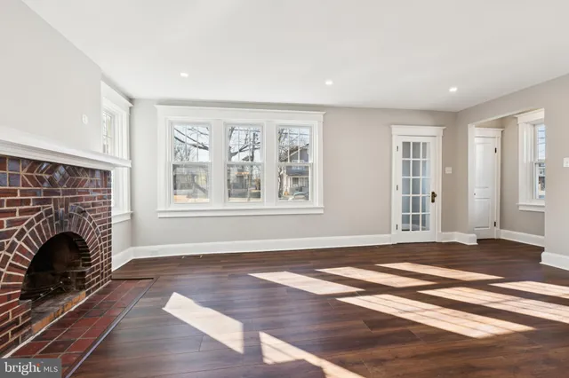 wooden floor fireplace and windows in an empty room