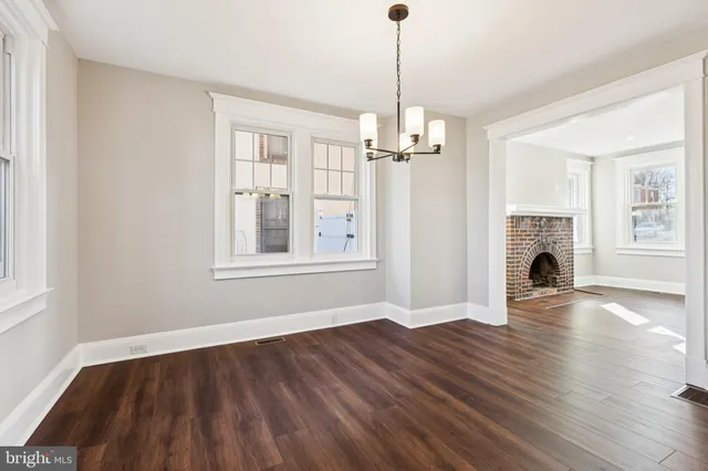 a view of empty room with wooden floor fireplace and window
