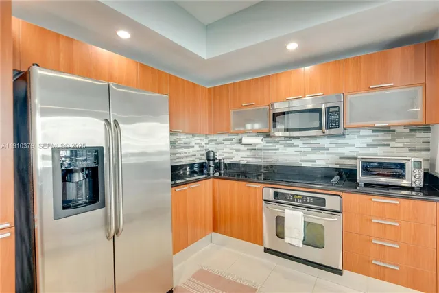 a kitchen with stainless steel appliances a refrigerator and a counter space