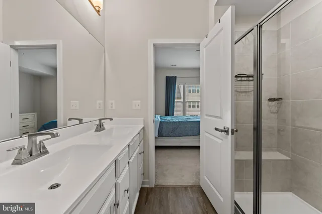 a en suite bathroom with a double vanity sink a mirror and shower