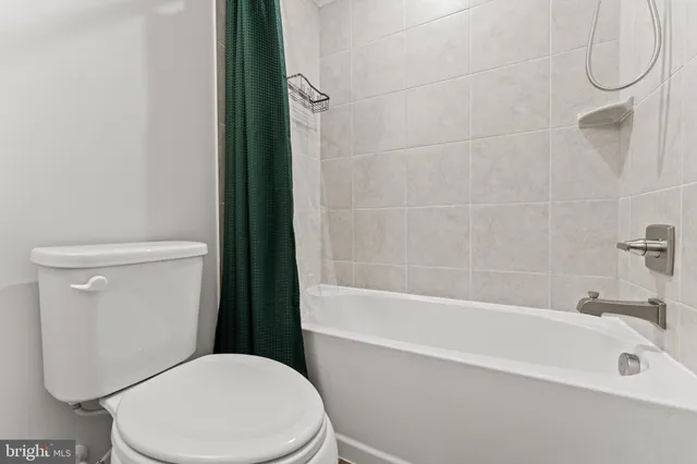 a white toilet sitting next to a bath tub