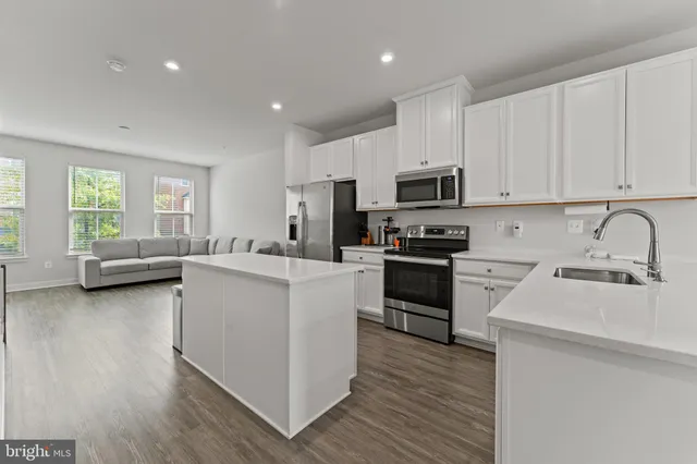 a kitchen with stove a sink and a refrigerator