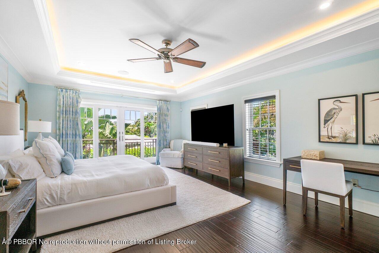 134 Seagate Road Palm Beach, FL 33480 - Photo 17 of 29 a spacious bedroom with a bed a couch and a flat screen tv