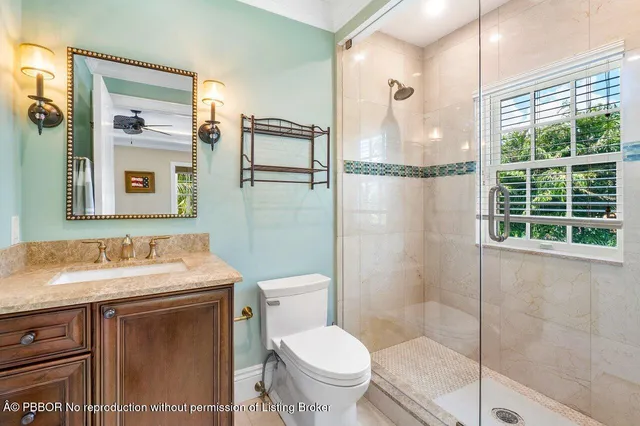 a bathroom with a granite countertop sink toilet and shower