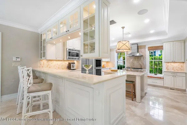 a kitchen with stainless steel appliances kitchen island granite countertop a table and chairs in it