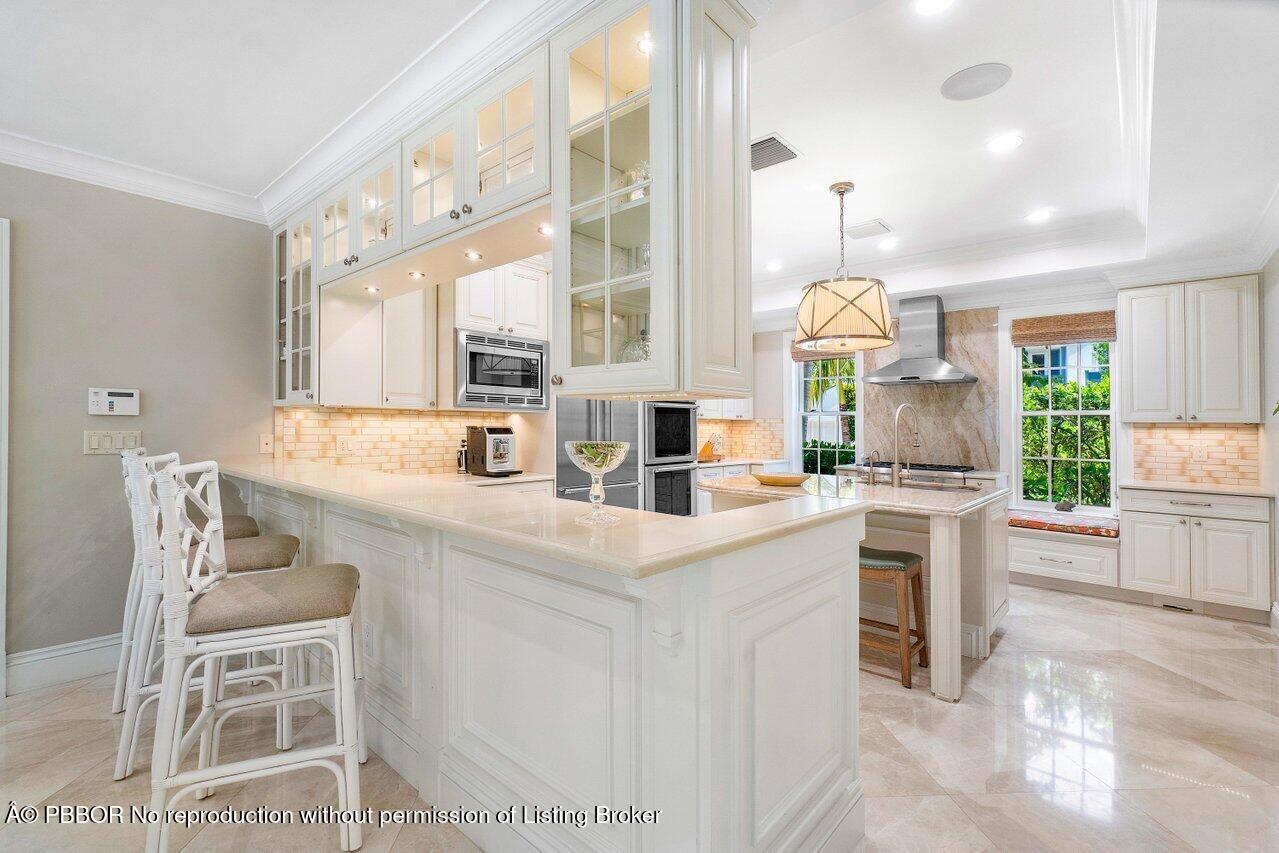 134 Seagate Road Palm Beach, FL 33480 - Photo 10 of 29 a kitchen with stainless steel appliances kitchen island granite countertop a table and chairs in it