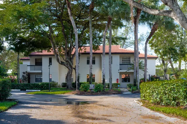 a front view of a house with a yard and potted plants