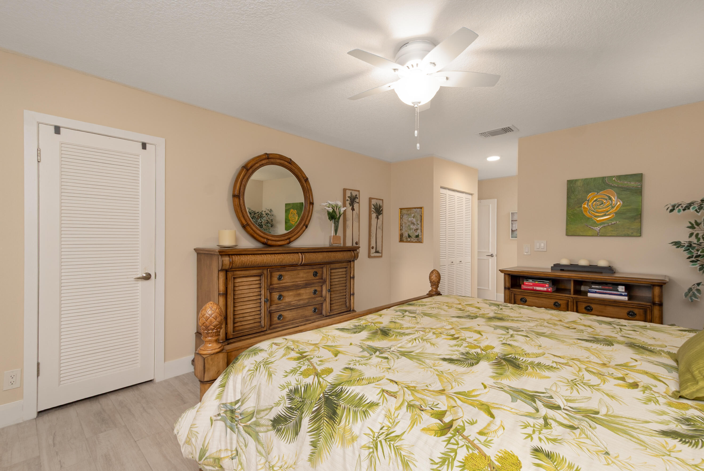 21703 Tall Palm Circle, Unit 5D Boca Raton, FL 33433 - Photo 21 of 36 a bedroom with a bed and a dresser with mirror