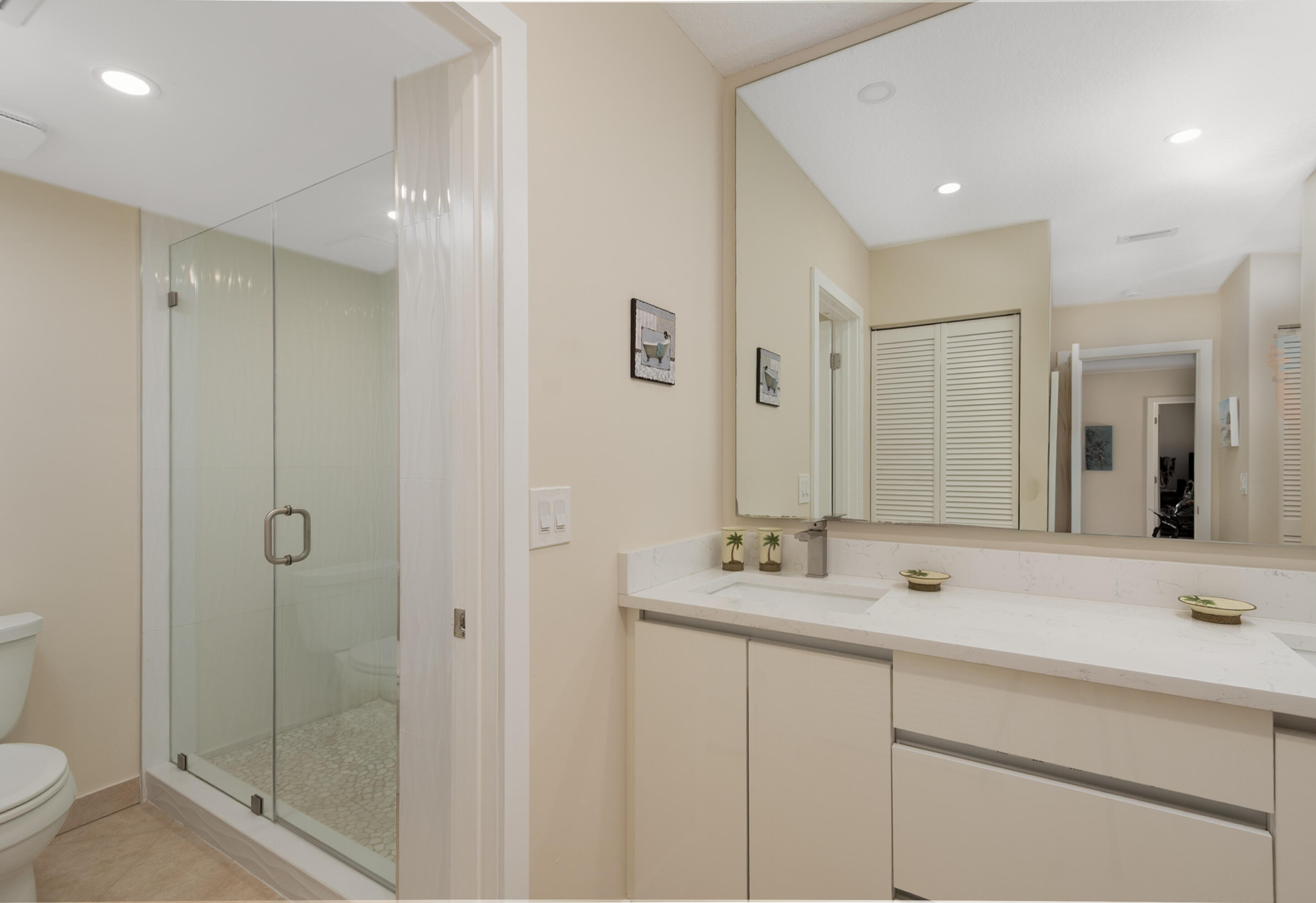 21703 Tall Palm Circle, Unit 5D Boca Raton, FL 33433 - Photo 23 of 36 a bathroom with a shower sink vanity and mirror