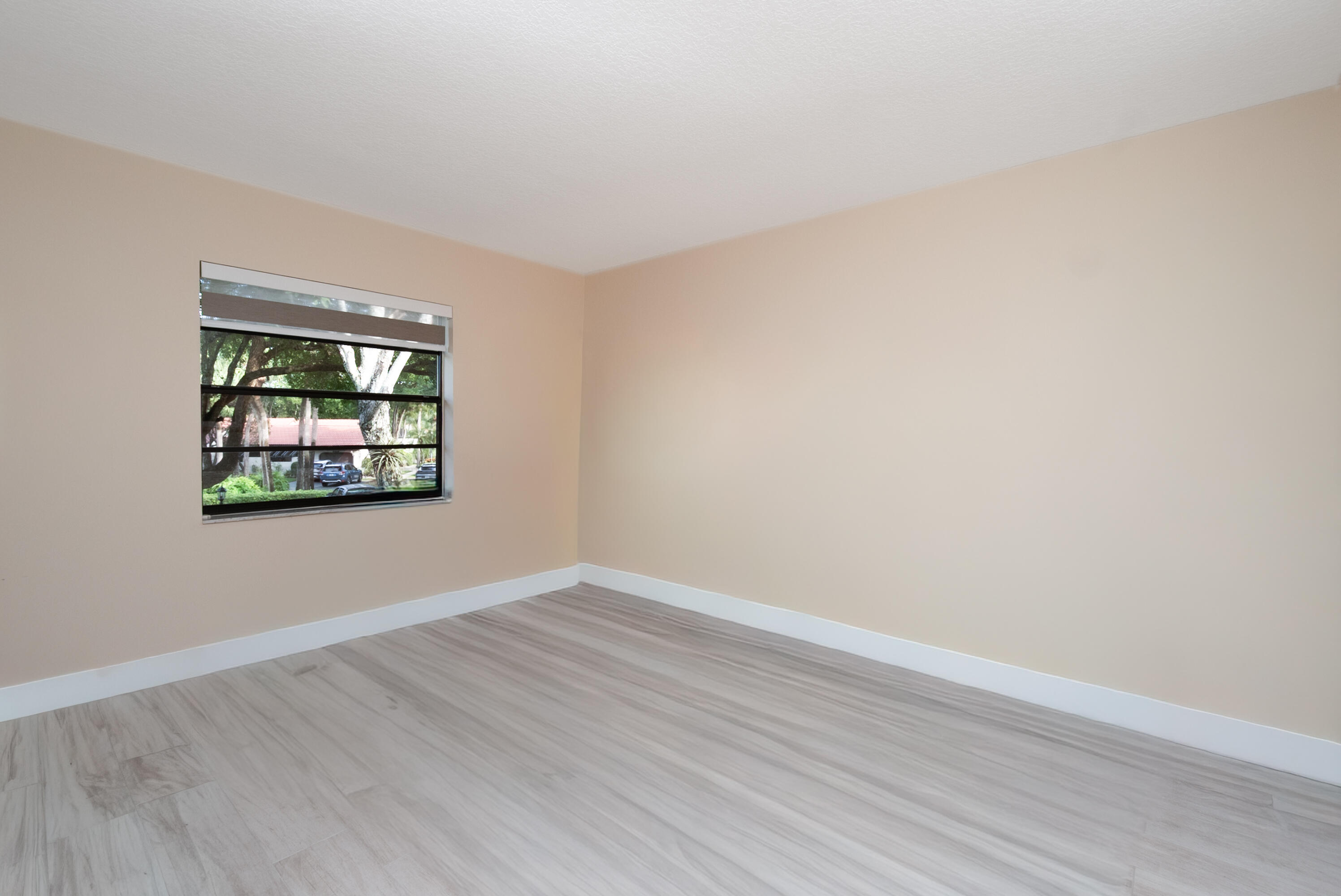 21703 Tall Palm Circle, Unit 5D Boca Raton, FL 33433 - Photo 27 of 36 a view of an empty room with wooden floor and a window