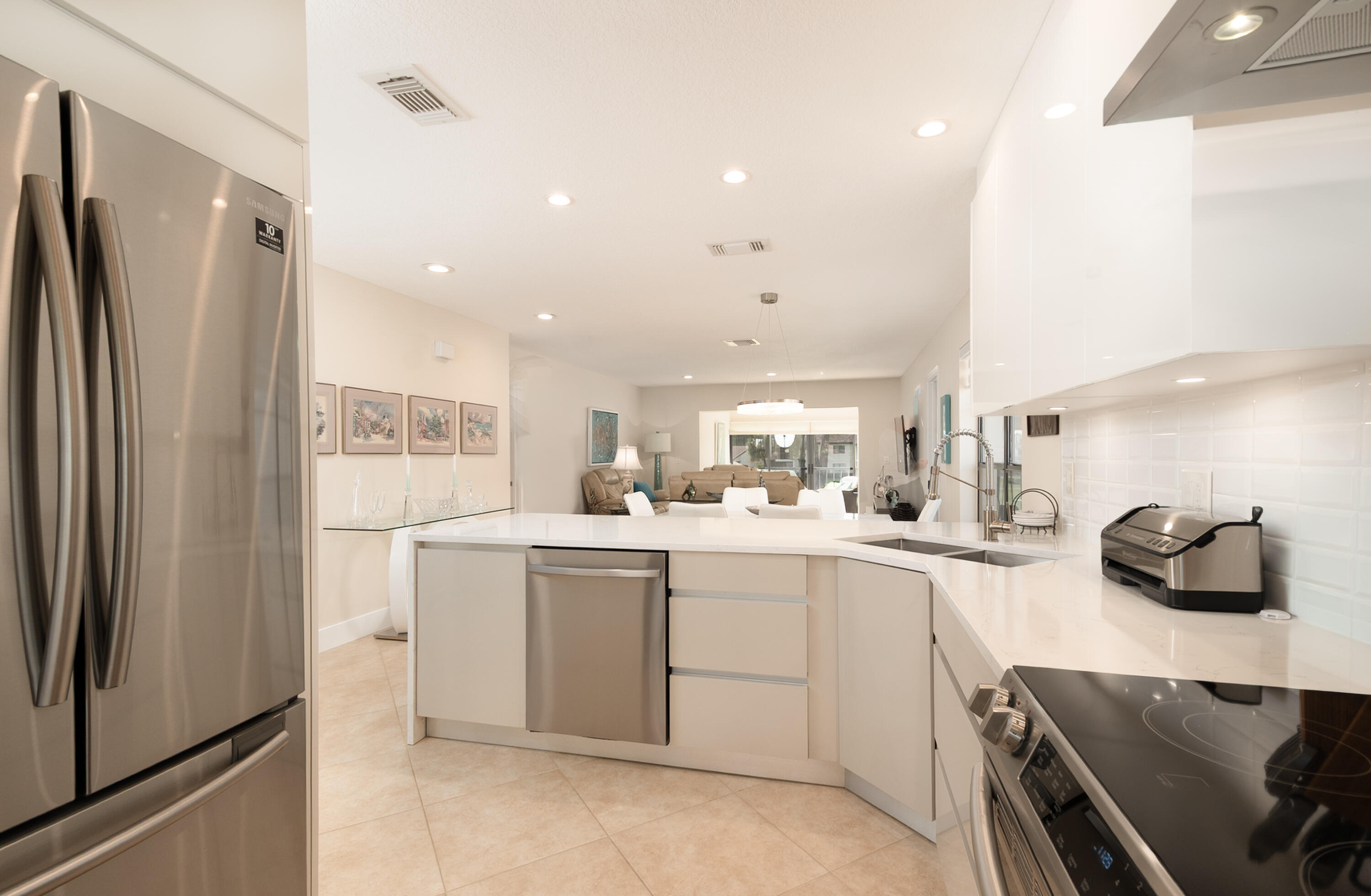 21703 Tall Palm Circle, Unit 5D Boca Raton, FL 33433 - Photo 10 of 36 a kitchen with a sink stainless steel appliances and cabinets