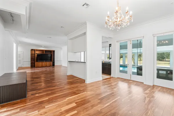 a view of empty room with wooden floor and windows