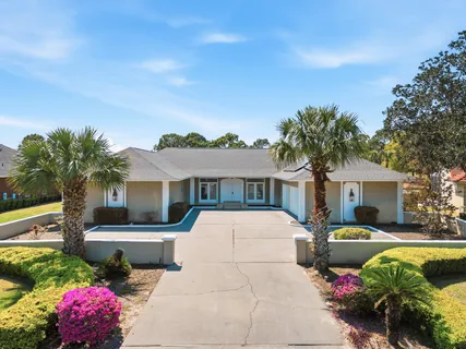 a front view of a house with a garden and swimming pool
