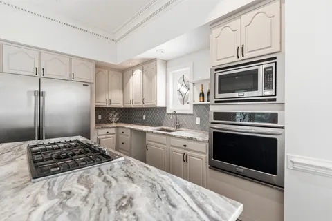 a kitchen with kitchen island granite countertop a sink and refrigerator