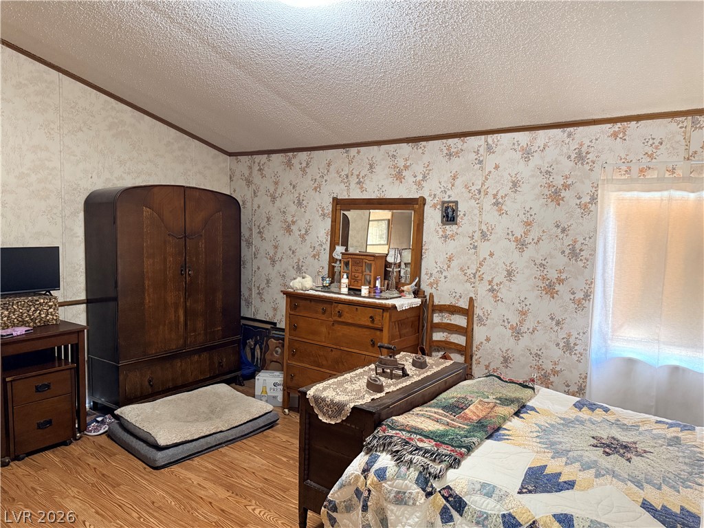 1391 West Dyer Road Pahrump, NV 89048 - Photo 34 of 50 A comforting bedroom space features wood flooring and a large window providing gentle illumination.