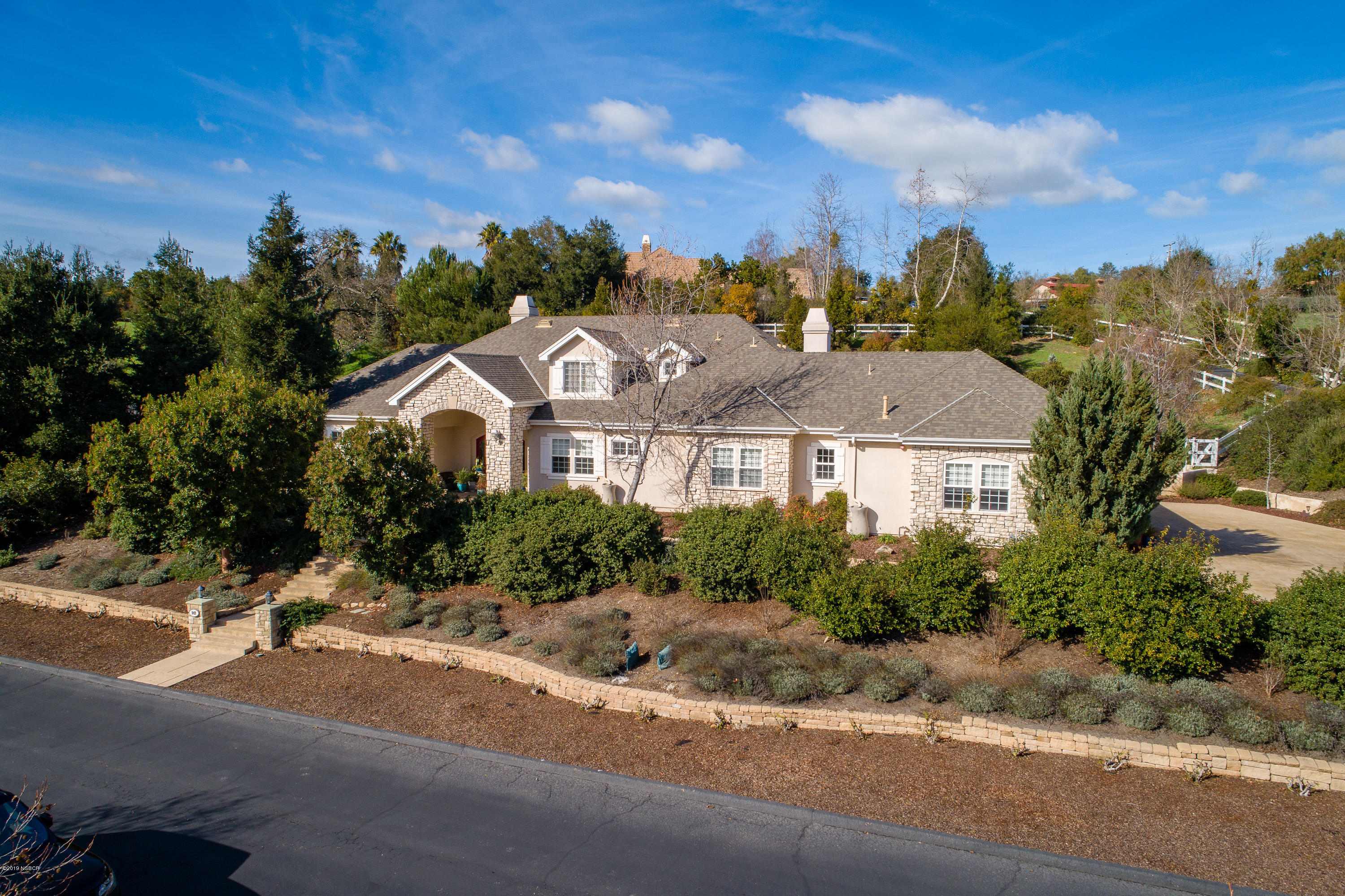 949 Old Ranch Road Solvang, CA 93463 - Photo 25 of 27 a view of a white house with a big yard plants and large trees