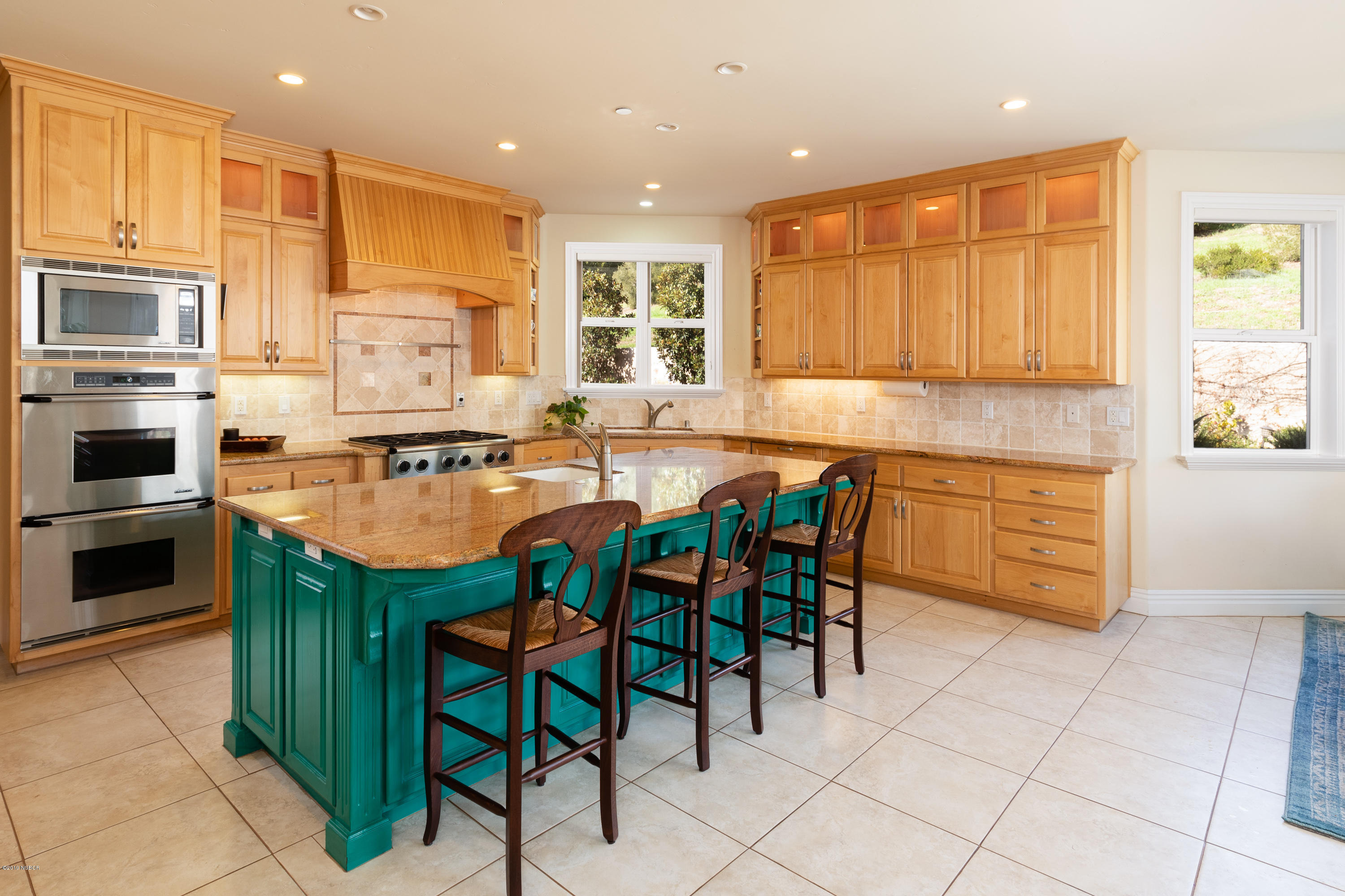 949 Old Ranch Road Solvang, CA 93463 - Photo 8 of 27 a kitchen with stainless steel appliances kitchen island granite countertop a stove a sink a microwave and a refrigerator