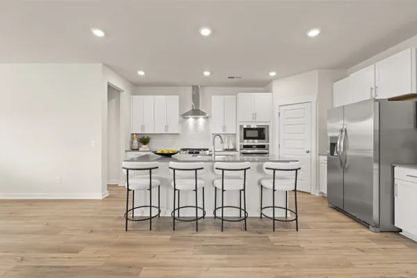 a kitchen with stainless steel appliances granite countertop a stove a sink a refrigerator and a microwave