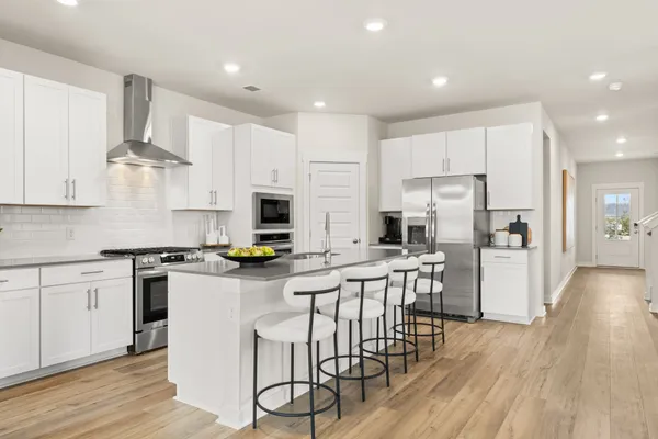 a kitchen with stainless steel appliances a stove a sink a refrigerator and a oven