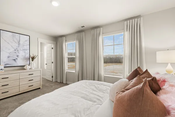 a bedroom with a bed and a large mirror with window