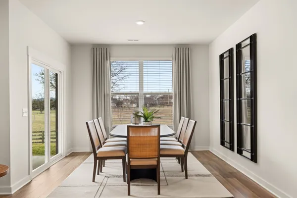 a dining room with furniture and large windows