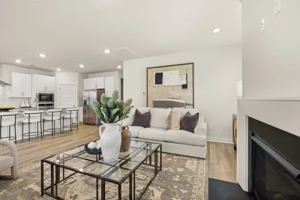 a living room with furniture white walls and kitchen view